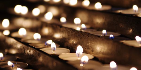 Rows of small lit candles creating a warm, serene atmosphere.