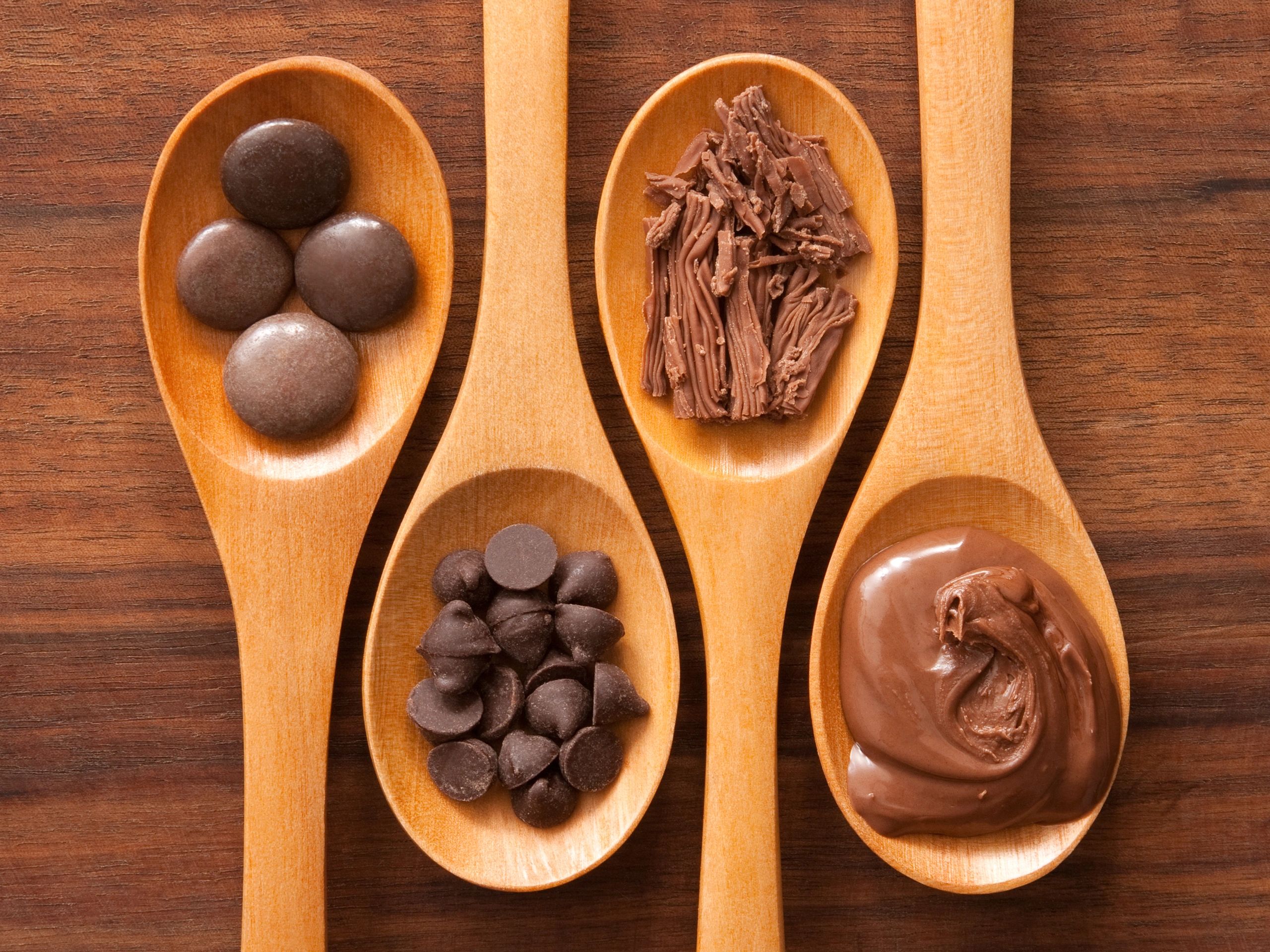 Cucharas de madera con diferentes presentaciones de chocolate.