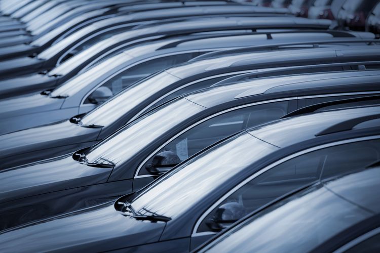 Rows of sleek, dark-colored cars parked closely together.
