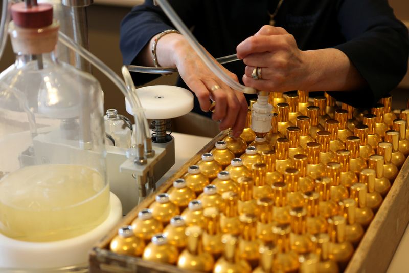 Bottles of perfumes, the worker is filling the bottles.