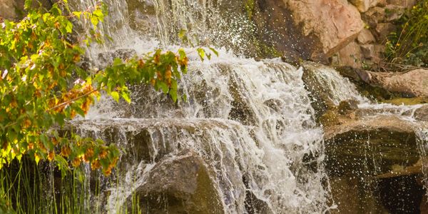 A serene waterfall cascading over rocks surrounded by greenery.