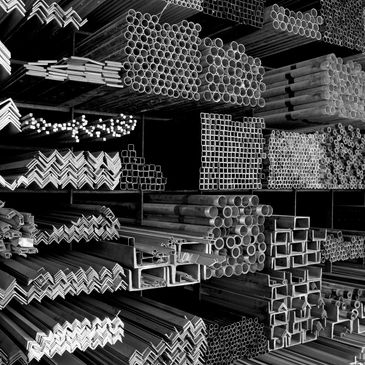 Stacks of various metal pipes and profiles.