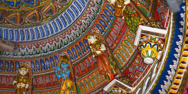 Intricately painted ceiling with colorful Hindu deity statues in traditional attire.
