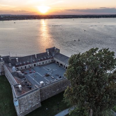 Château au bord de l'eau au coucher du soleil.