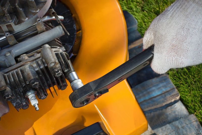 A detailed close-up of a man expertly repairing a lawn mower, showcasing the intricacies of lawn mowing equipment maintenance.