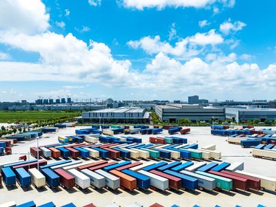 Aerial view of a large logistics hub with colorful cargo trailers lined up.