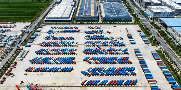 Aerial view of organized shipping containers at a logistics hub.