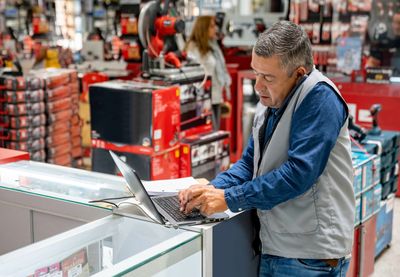 Man working on laptop in a hardware store.