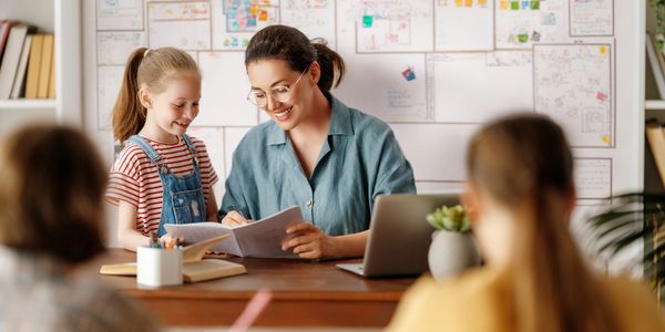 alt="teacher speaking to a diverse group of students in an inclusive classroom setting"
