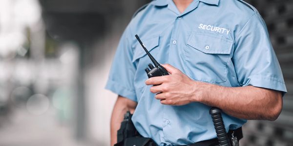 Security guard in blue uniform holding a walkie-talkie.