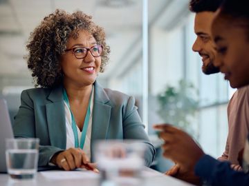 Confident businesswoman smiling during a meeting with colleagues.