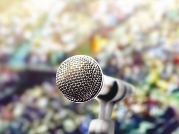 Close-up of a microphone with a blurred colorful background.