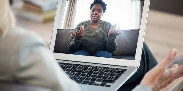 Woman in a video call explaining something with hand gestures.