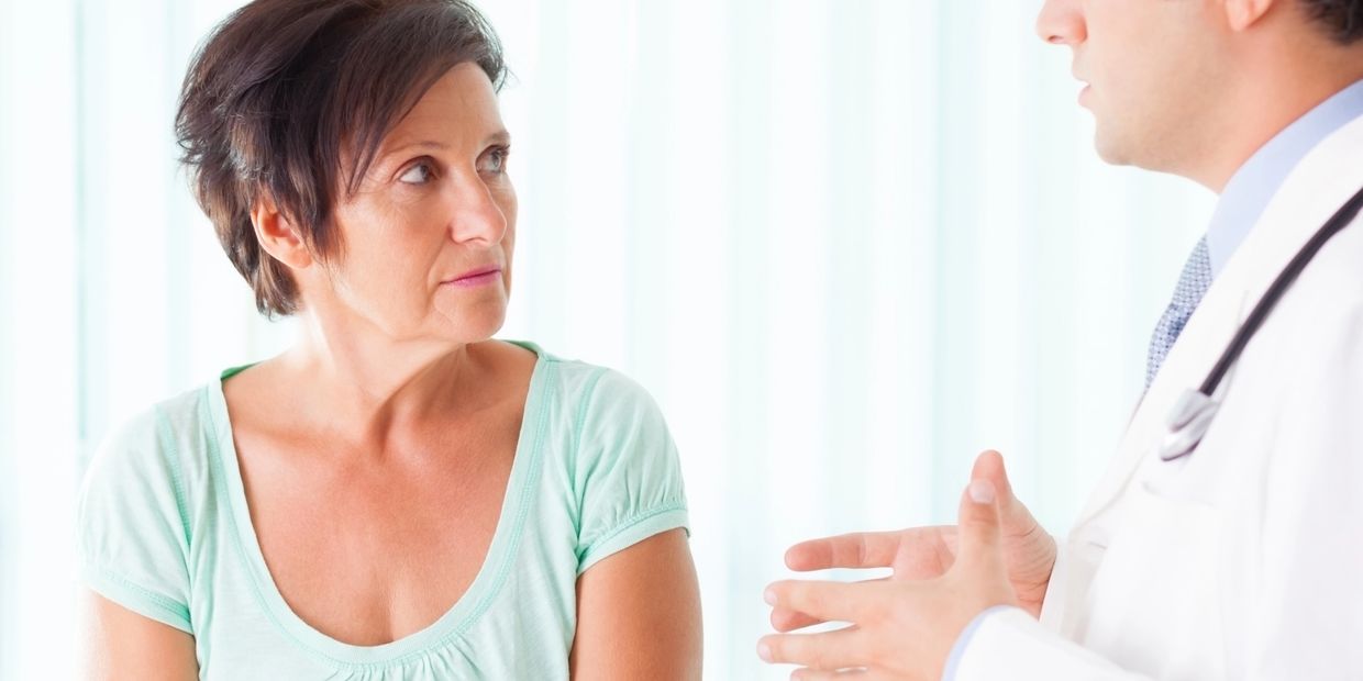Doctor consulting a concerned female patient in a bright room.