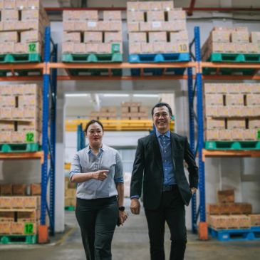 Two professionals walking confidently in a warehouse.