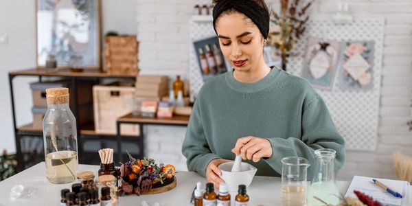 Woman preparing natural remedies in a cozy setting.