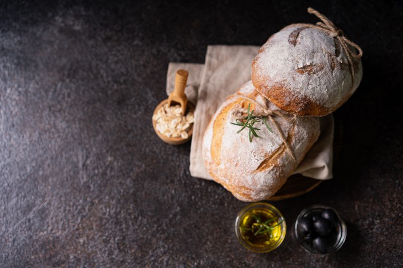 Fresh organic homemade artisan ciabatta bread on dark rustic background. sourdough bread
