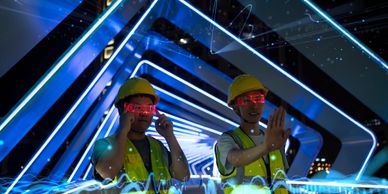 Two construction workers wearing yellow helmets and neon glasses with futuristic blue lights.
