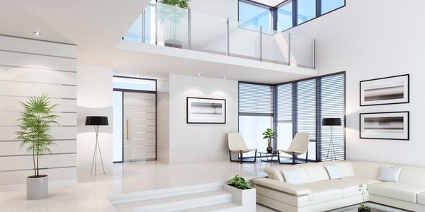 Bright modern living room with white furniture and large windows.