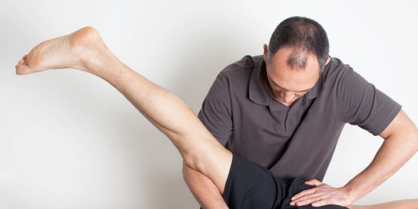 Physical therapist helping a patient with leg exercises.