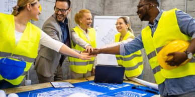 Engineers celebrating teamwork at a construction site.