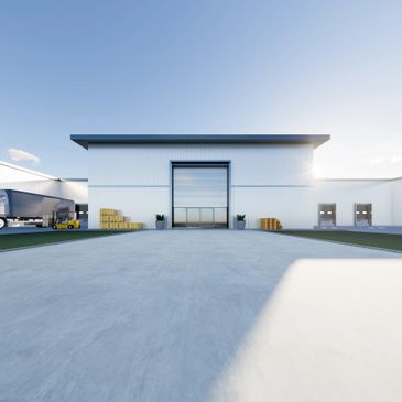 Modern warehouse building with loading docks and trucks under clear sky.