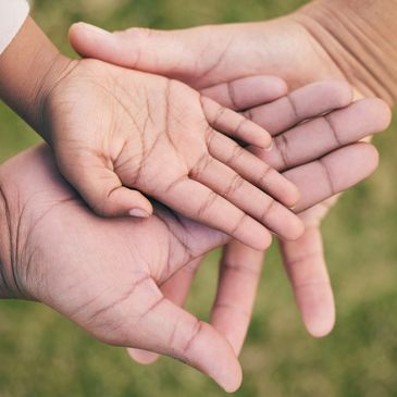 Close-up of adult and child hands together symbolizing care.