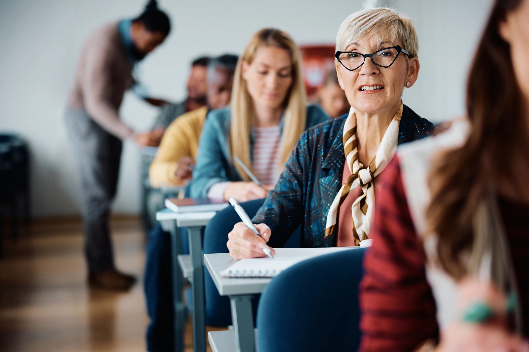 Older woman smiling in a classroom.