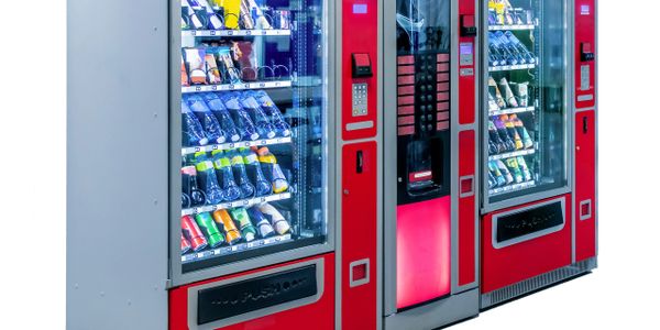 Two red vending machines filled with snacks and drinks.