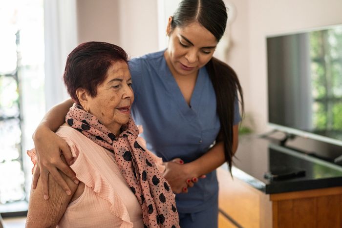 Aide supporting the client as the client walks