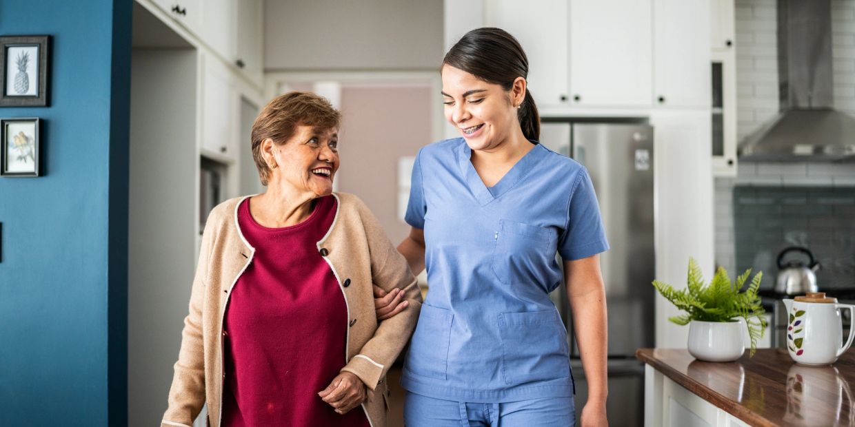 Caregiver assisting an elderly woman at home.