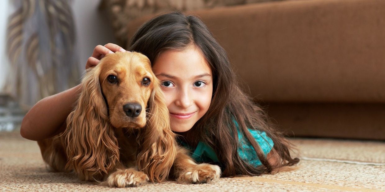 Girl lying on the floor with a dog.