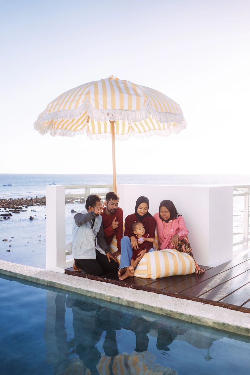 Indonesian family reunion in a beautiful beach house having BBQ and playing at the beach