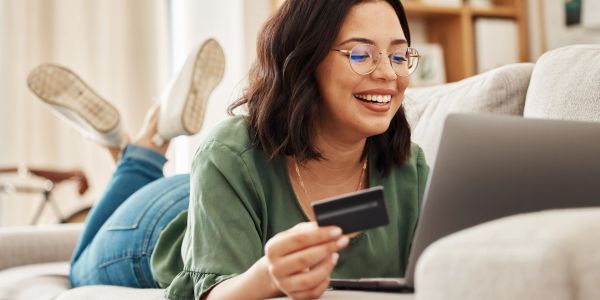 Young woman shopping online with credit card and laptop.