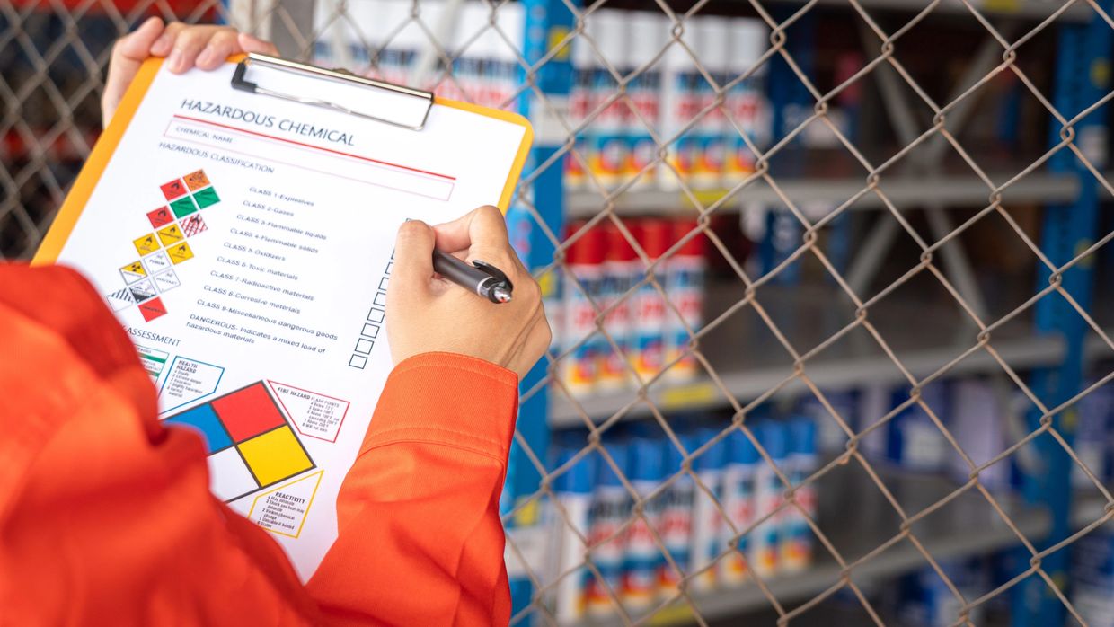 Person inspecting hazardous chemicals checklist.