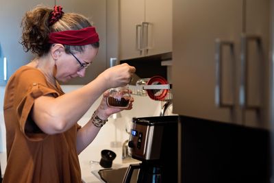 A visually impaired young lady cooking in her kitchen at home.