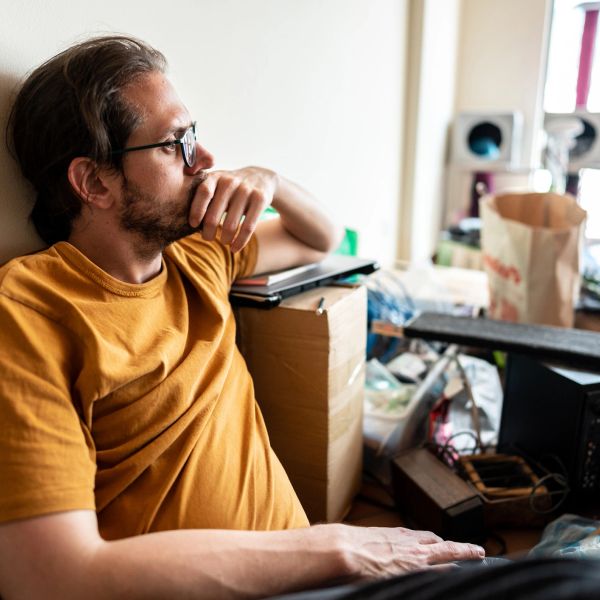 Man in glasses staring thoughtfully.