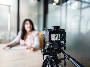 Camera recording a woman in a business setting.