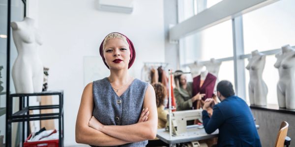 Confident woman standing in a fashion design studio.