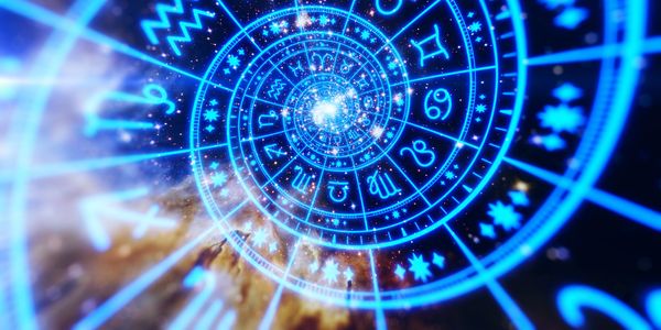 Glowing spiral of zodiac signs against a cosmic background.
