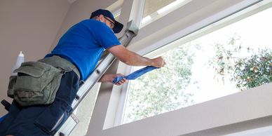 Window cleaner on ladder cleaning interior window