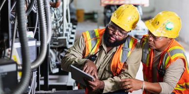 Two industrial workers inspecting machinery.