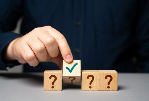 Hand placing a wooden block with a green check mark.