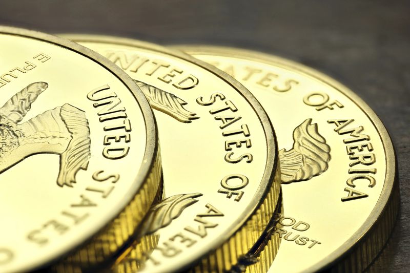 1 ounce American gold eagle bullion coins on wooden background
