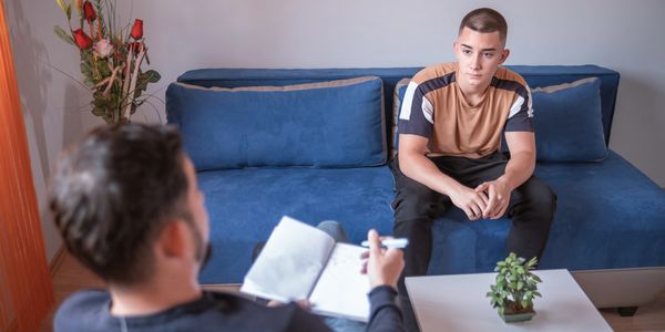 A young man attentively listens during a therapy session.