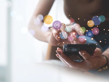 Someone on a phone with bubbles showing all of the apps.