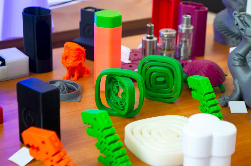 Multicolored 3D printed models close-up. Objects printed on 3D printer from plastic close-up. 3D printed forms. Prototypes of various shapes made by 3d printer. Concept new modern printing technology