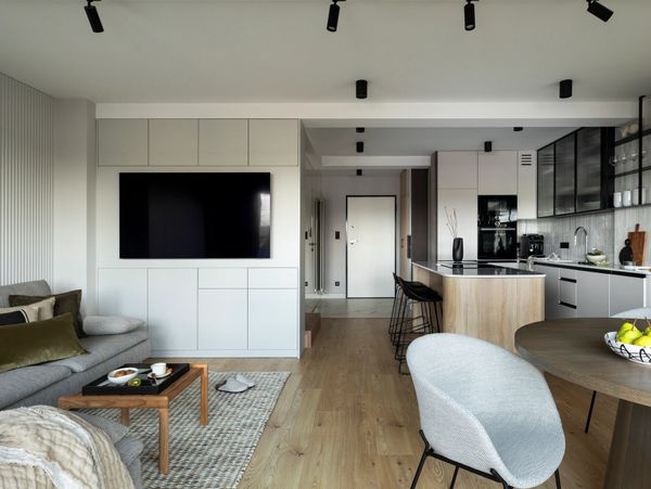 Modern open-plan living room and kitchen with minimalist design and neutral tones.