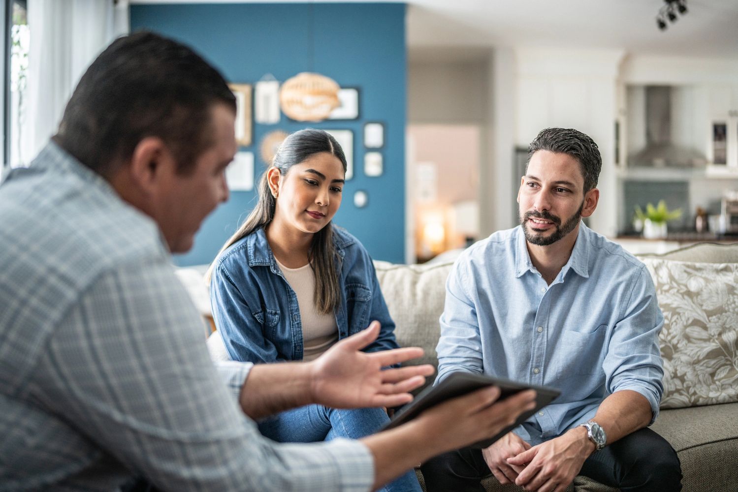 Three adults engaged in a serious discussion at home.