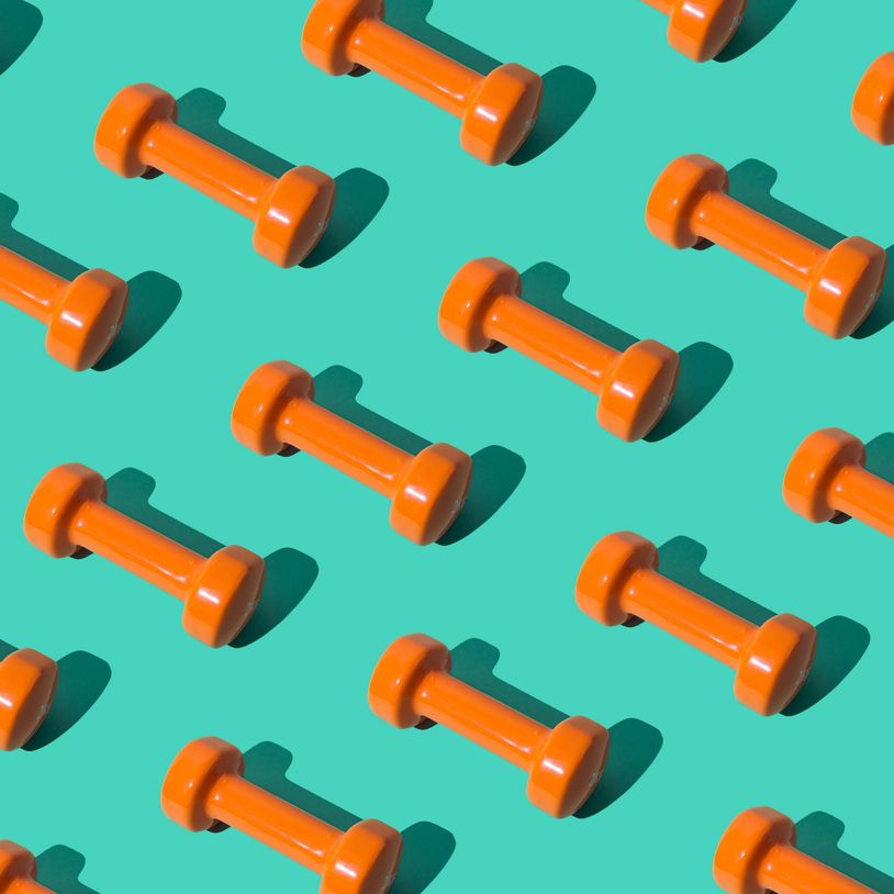 Pattern of orange dumbbells on a teal background casting shadows.